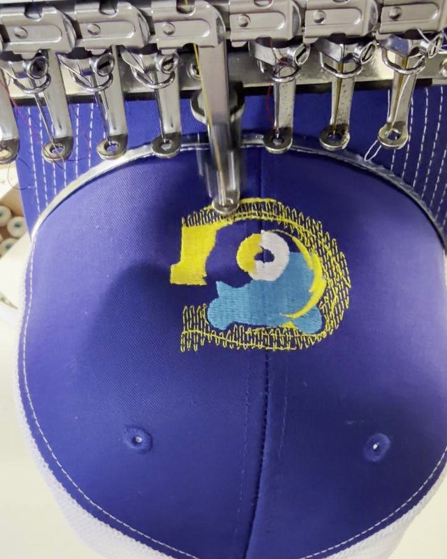 Custom cap being embroidered at 77859 Designs