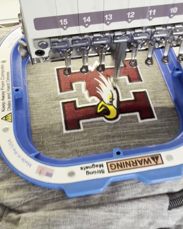 Embroidery machine stitching a Hearne Eagles logo